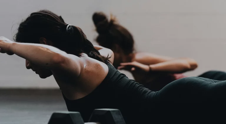 Femme réalisant des crunchs dans une salle de sport à Beynost, axée sur le renforcement abdominal.