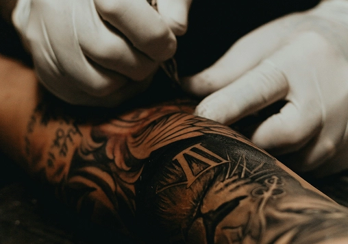 Tatouage sportif sur bras musclé, expression de soi fréquente chez les adeptes de salle de sport à Beynost.