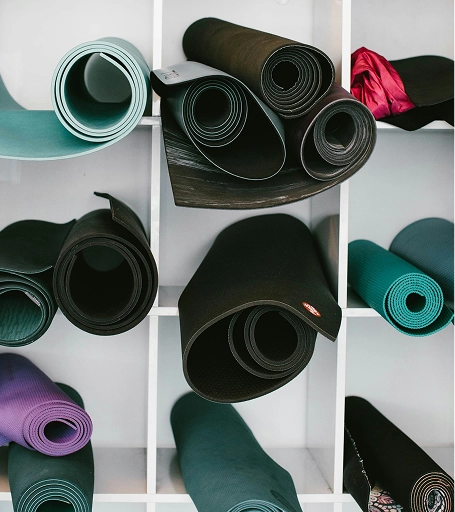 Tapis de yoga multicolores enroulés, prêts pour une séance de yoga ou pilates