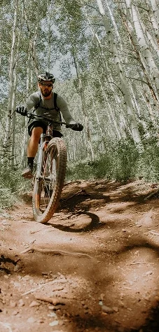 Cycliste en VTT sur un sentier poussiéreux autour de Beynost, allié du renforcement cardio en extérieur.