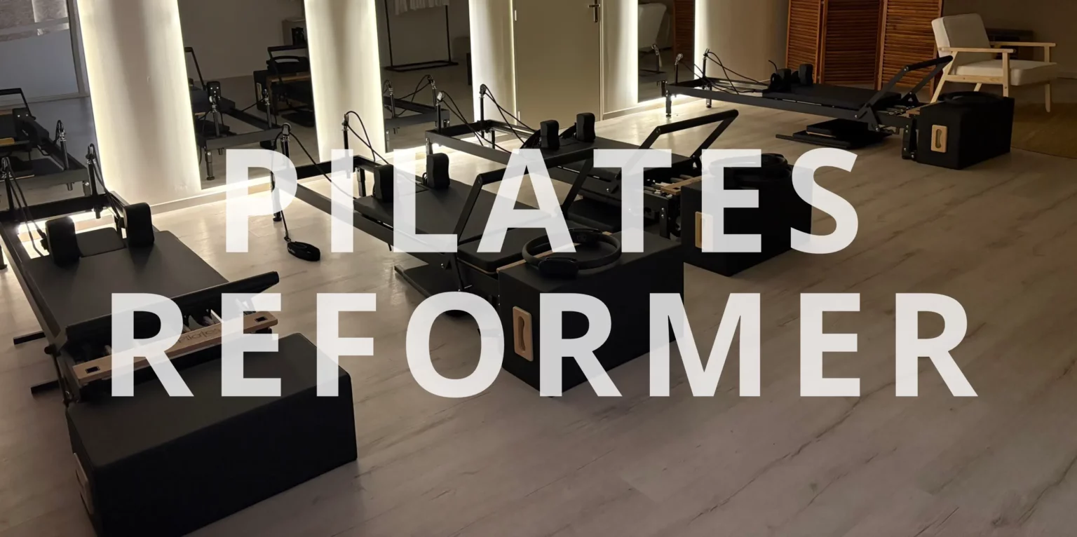 Salle de sport équipée de machines Pilates Reformer, idéale pour les entraînements de renforcement musculaire, d'étirement et de gainage en Pilates.