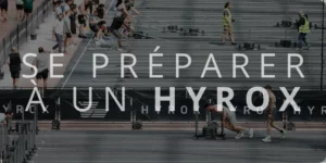 Se préparer à un Hyrox' en grand format, superposé sur une compétition de fitness où des athlètes réalisent des épreuves de sled push et sled pull.