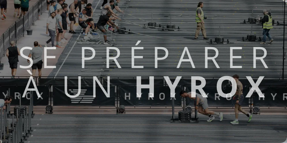 Se préparer à un Hyrox' en grand format, superposé sur une compétition de fitness où des athlètes réalisent des épreuves de sled push et sled pull.
